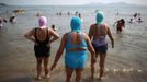 Women, wearing nylon masks, walk towards the sea during their visit to a beach in Qingdao, Shandong province July 6, 2012. The mask, which was invented by a woman about seven years ago, is used to block the sun's rays. The mask is under mass production and is on sale at local swimwear stores. REUTERS/Aly Song (CHINA - Tags: SOCIETY ENVIRONMENT TRAVEL) Published: Čec. 6, 2012, 4:10 odp.