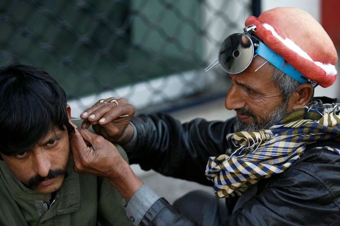 Povolání, o kterém jste dost možná ani netušili, že existuje, zachytil fotograf Reuters v Lahore v Pákistánu. Na snímku je pětapadesátiletý Nazir Ahmed, pouliční čistič uší.