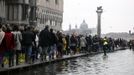 Tourists walk on raised platforms for flood waters in St. Mark Square during a period of seasonal high water in Venice October 27, 2012. The water level in the canal city rose to 127 cm (50 inches) above the normal level, according to the monitoring institute. REUTERS/Manuel Silvestri (ITALY - Tags: ENVIRONMENT SOCIETY TRAVEL) Published: Říj. 27, 2012, 11:52 dop.