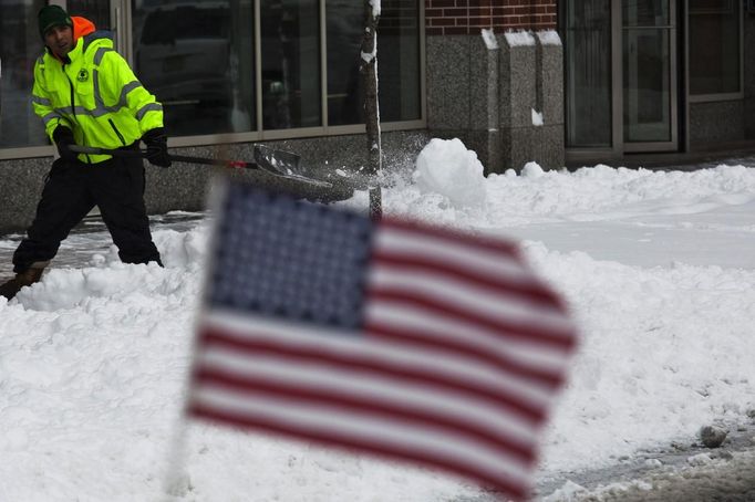 A man shovels the sidewalk after the pass of a winter storm in Hoboken in New Jersey, February 9, 2013. A record-breaking blizzard packing hurricane-force winds pummeled the northeastern United States on Saturday, causing at least two storm-related deaths, cutting power to 700,000 homes and businesses and shutting down travel. REUTERS/Eduardo Munoz (UNITED STATES - Tags: ENVIRONMENT) Published: Úno. 9, 2013, 5:51 odp.