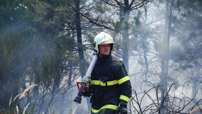 Hasič zasahuje v lese u Lomnice na Tišnovsku.