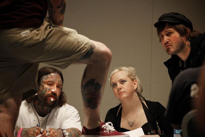 Tattoo judges inspect the tattoos of a competitor at the Hampton Roads Tattoo Festival in Virginia, March 2, 2012. The hobby of collecting tattoos has exploded into the mainstream of society with tattoo conventions and festivals held year-round across the United States. Picture taken March 2, 2012. REUTERS/Larry Downing (UNITED STATES - Tags: SOCIETY) ATTENTION EDITORS PICTURE 20 OF 31 FOR PACKAGE 'ADDICTED TO THE NEEDLE' TO FIND ALL PICTURES SEARCH 'ADDICTED NEEDLE' Published: Čer. 29, 2012, 1 odp.