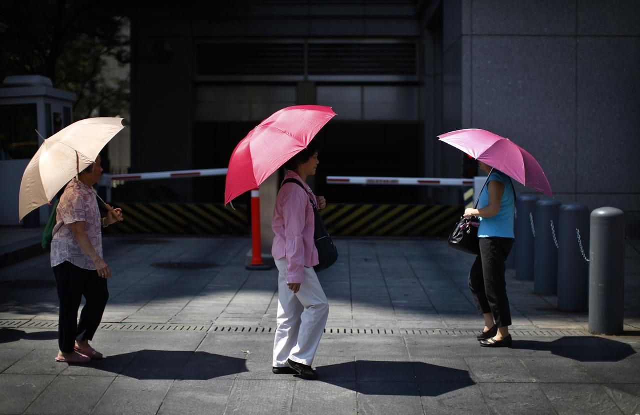 Сколько лет зонтику. Под зонтом от солнца. Люди под зонтиком от солнца. Девушка под зонтом от солнца. Человек прячется под зонтом.
