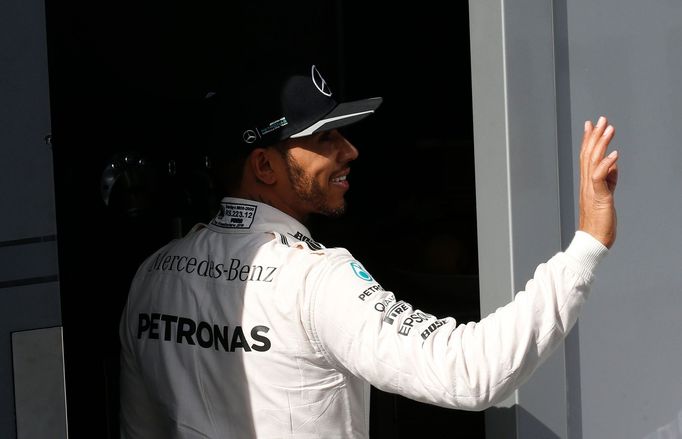 Mercedes F1 driver Lewis Hamilton waves to supporters in the paddock.