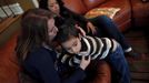 Theresa Volpe (L) kisses her son Jaidon as her partner Mercedes Santos looks on at their home in Chicago, Illinois December 22, 2012. Santos and Volpe are a same-sex couple raising two of their biological children as they struggle to get same-sex marriages passed into law in Illinois. Picture taken December 22, 2012. REUTERS/Jim Young (UNITED STATES - Tags: SOCIETY) Published: Bře. 25, 2013, 6:06 odp.