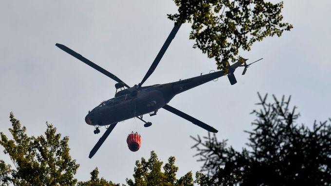 Foto: Požár v Českém Švýcarsku likviduje i armádní vrtulník. Bambi vak plní v Labi