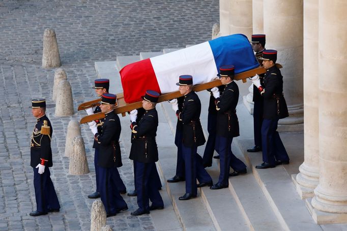 Příslušníci republikánské gardy vynášejí z Invalidovny rakev Charlese Aznavoura přikrytou francouzskou vlajkou.