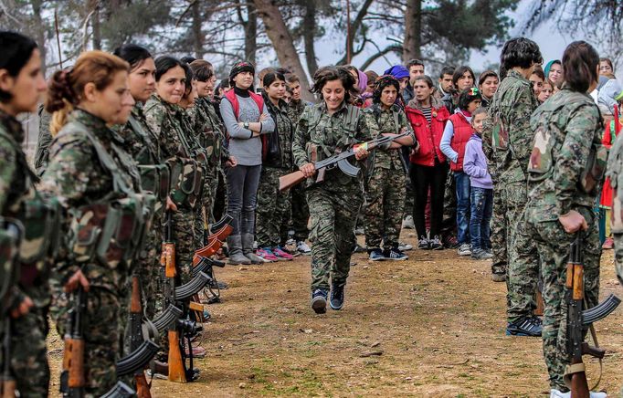 A female fighter of the Kurdish People's Protection Units (YPG) goes back to her place after receiving her military card at a military camp in Ras a-Ain, January 30, 2015