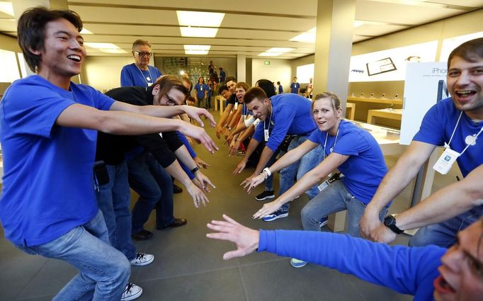 Employees welcome customers at an Apple store before the release of iPhone 5 in Munich early September 21, 2012. Apple Inc's iPhone 5 hit stores around the globe on Friday, with fans snapping up the device that is expected to fuel a huge holiday quarter for the consumer giant. REUTERS/Michael Dalder (GERMANY - Tags: BUSINESS TELECOMS) Published: Zář. 21, 2012, 7:36 dop.