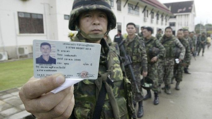 Thajský voják v provincii Yala ukazuje ve frontě před volební místností svůj identifikační průkaz