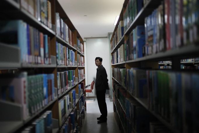 An employee stands in the library at a communist party school called China's Executive Leadership Academy of Jinggangshan, in Jiangxi province, September 20, 2012. China has yet to announce the start date for the 18th Communist Party Congress, China's biggest political meeting in 10 years, which will see the transfer of power from President Hu Jintao and Premier Wen Jiabao to a new generation. REUTERS/Carlos Barria (CHINA - Tags: POLITICS) Published: Zář. 20, 2012, 4:40 odp.