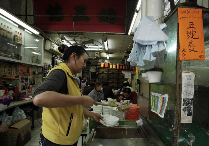 A worker prepares snake soup for customers in snake soup shop in Hong Kong January 29, 2013. There are scores of people in Hong Kong who have through generations tamed snakes to make soup out of them, a traditional cuisine believed to be good for the health. Yet the people behind providing fresh snakes for the savoury meal thought to speed up the body's blood flow and keep it strong in the cold winter months may be doomed, with young people increasingly reluctant to take on a job they see as hard and dirty. Picture taken January 29, 2013. REUTERS/Bobby Yip (CHINA - Tags: ANIMALS FOOD SOCIETY) Published: Úno. 7, 2013, 2:01 odp.