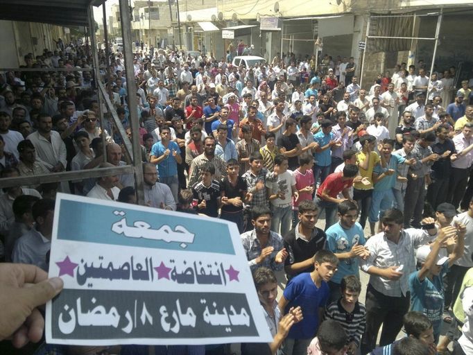 Demonstrators protest against Syria's President Bashar al-Assad after Friday prayers in Maraa, near Aleppo, July 27, 2012. The placard reads: "Friday of the two capitals (Damasucs and Aleppo) uprising". REUTERS/Shaam News Network/Handout (SYRIA - Tags: POLITICS CIVIL UNREST) FOR EDITORIAL USE ONLY. NOT FOR SALE FOR MARKETING OR ADVERTISING CAMPAIGNS. THIS IMAGE HAS BEEN SUPPLIED BY A THIRD PARTY. IT IS DISTRIBUTED, EXACTLY AS RECEIVED BY REUTERS, AS A SERVICE TO CLIENTS Published: Čec. 27, 2012, 7:56 odp.