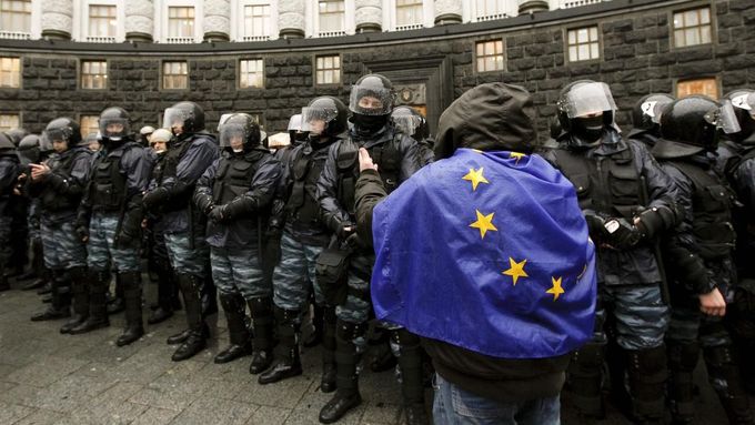 Dnes už historický snímek z Kyjeva. Demonstrant prochází kolem - mezitím zrušených - jednotek Berkut poté, co tehdejší prezident Viktor Janukovyč odmítl podepsat asociační dohodu s EU.