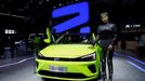 A model stands next to a Roewe ER6 electric vehicle (EV) of SAIC Motor during a media day for the Auto Shanghai show in Shanghai, China April 19, 2021. REUTERS/Aly Song