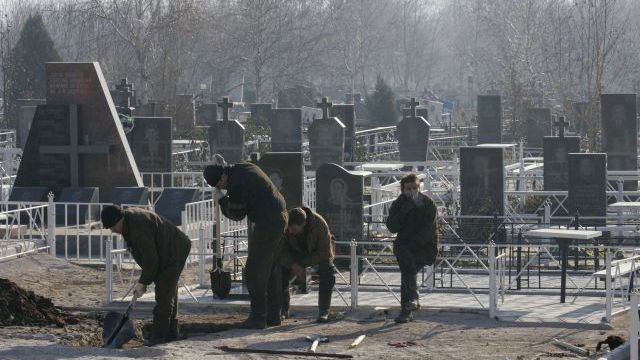 Ukrajinští horníci kopou na hřbitově v Doněcku hrob pro svého kolegu, který zahynul při explozi na dole Zasjadko.