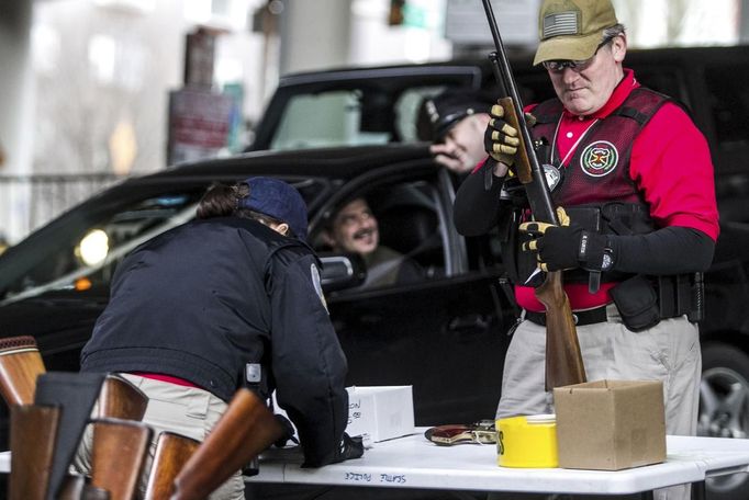 A Seattle Police Officer inspects a rifle during the gun buyback event in Seattle, Washington, January 26, 2013. Participants received up to a $100 gift card in exchange for working handguns, shotguns and rifles, and up to a $200 gift card for assault weapons. REUTERS/Nick Adams (UNITED STATES - Tags: POLITICS CIVIL UNREST) Published: Led. 27, 2013, 12:41 dop.