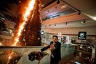 Příslušník ochranky nákupního centra se snaží uhasit hořící vánoční stromek poté, co obchodní dům zasáhly protivládní protesty. Autorem snímku je Thomas Peter.