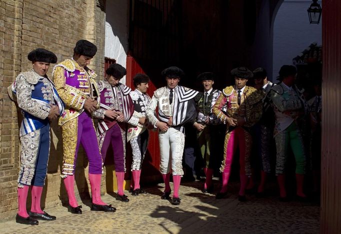 Bullfighters and their assistants stand before the start of a bullfight in The Maestranza bullring in Seville