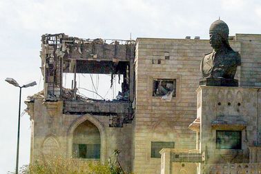 Socha Saddáma Husajna na střeše Qasr al-Salam v Bagdádu, zasaženého americkou střelou 22. března 2003 během leteckých útoků na město.