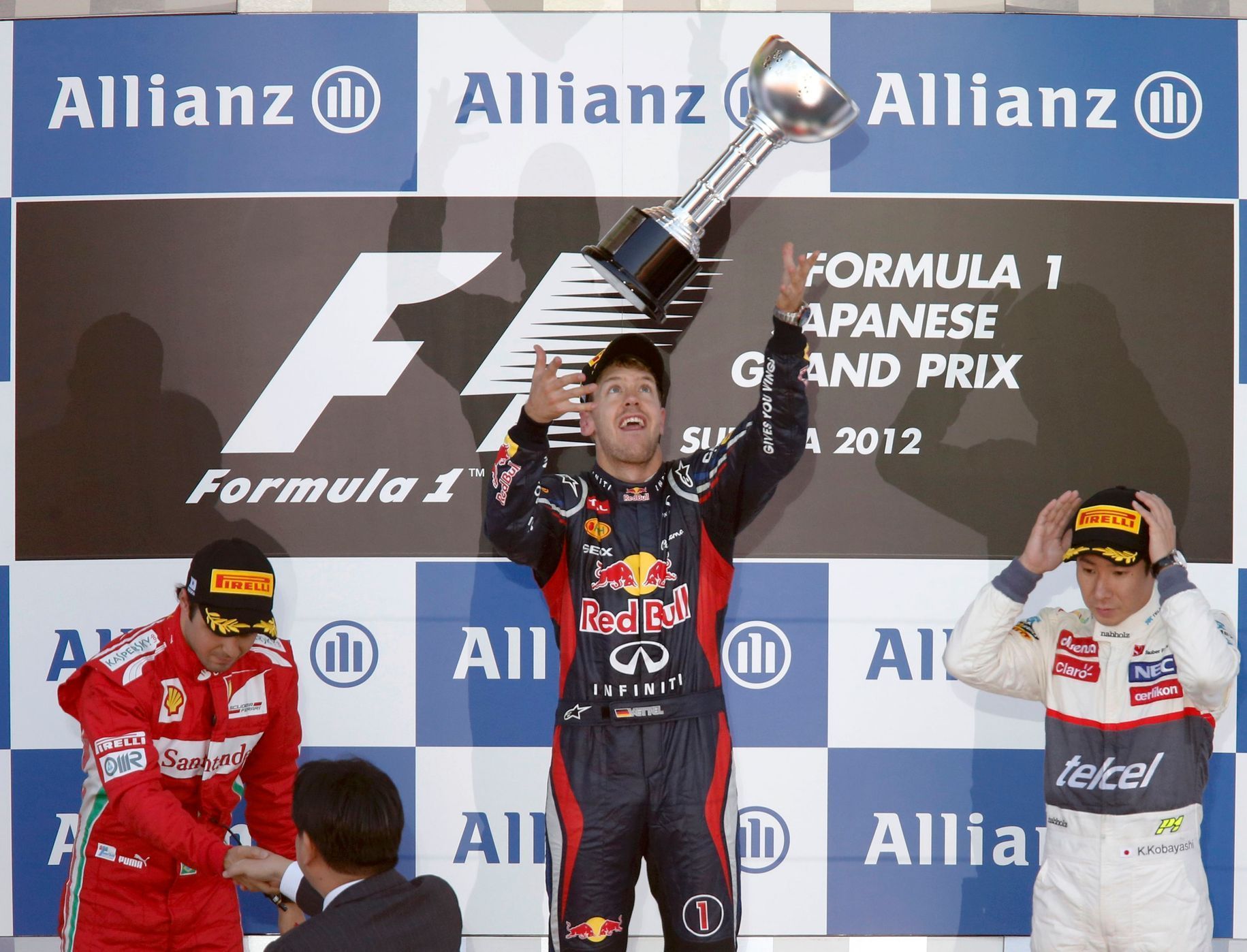 Sebastian Vettel si pohrává s trofejí za vítězství ve VC Japonska, vedle něj Felipe Massa a Kamui Kobajaši