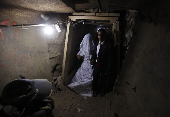 ¨ Palestinian groom Emad al-Malalha, 21, walks with Manal Abu Shanar, 17, his Egyptian bride inside a smuggling tunnel beneath the Gaza-Egypt border in the southern Gaza Strip March 21, 2013. Al-Malaha, who said that his bride was not given a permit from Egyptian authorities to enter the Gaza Strip, brought her from neighboring Egypt through a smuggling tunnel to celebrate his wedding in his native Gaza Strip. REUTERS/Ibraheem Abu Mustafa (GAZA - Tags: POLITICS SOCIETY TPX IMAGES OF THE DAY) Published: Bře. 21, 2013, 6:13 odp.