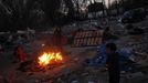 Israel Duval (R) and his cousin Desiree feed debris from his grandfather's home to a bonfire at the Spanish gypsy settlement of Puerta de Hierro outside Madrid February 15, 2012. Fifty-four families have been living in Puerta de Hierro, on the banks of the Manzanares river for over 50 years. Since the summer of 2010, the community has been subject to evictions on the grounds that the dwellings are illegal. Families whose houses have been demolished, move in with relatives whose houses still remain while the debris keeps piling up around them as more demolitions take place. Picture taken February 15, 2012. REUTERS/Susana Vera (SPAIN - Tags: SOCIETY) ATTENTION EDITORS - PICTURE 28 OF 31 FOR PACKAGE 'GYPSY SITE DEMOLISHED' SEARCH 'GYPSY SITE' FOR ALL IMAGES Published: Lis. 5, 2012, 4:12 odp.