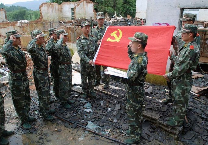 Před domem, který se zřítil po průtrži mračen, jež postihla okres Zhaoping v provincii Guangxi Zhuang´ v červnu, skládají vojáci přísahu věrnosti Komunistické straně Číny. 1. července uplynulo 87 let od jejího založení.