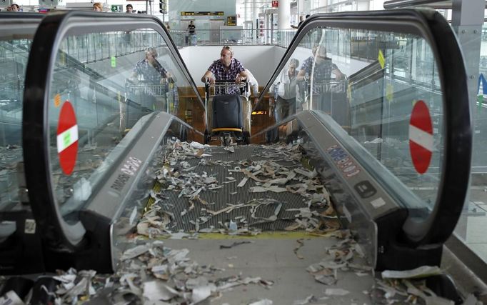 A passenger pushes a trolley up a travelator during a protest by the cleaning staff at Barcelona's airport May 29, 2012. Cleaning staff working for a company which has a contract with the airport demonstrated against pay and benefits cuts made by their employer. REUTERS/Albert Gea (SPAIN - Tags: CIVIL UNREST BUSINESS TRANSPORT) Published: Kvě. 29, 2012, 5:14 odp.