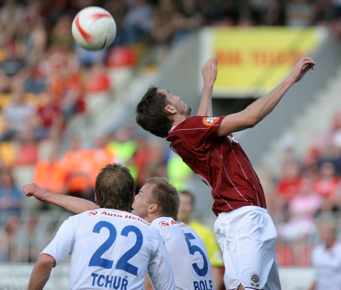 Tomáš Sivok hlavičkuje nad Tchuřem a Bolfem před brankou Baníku.