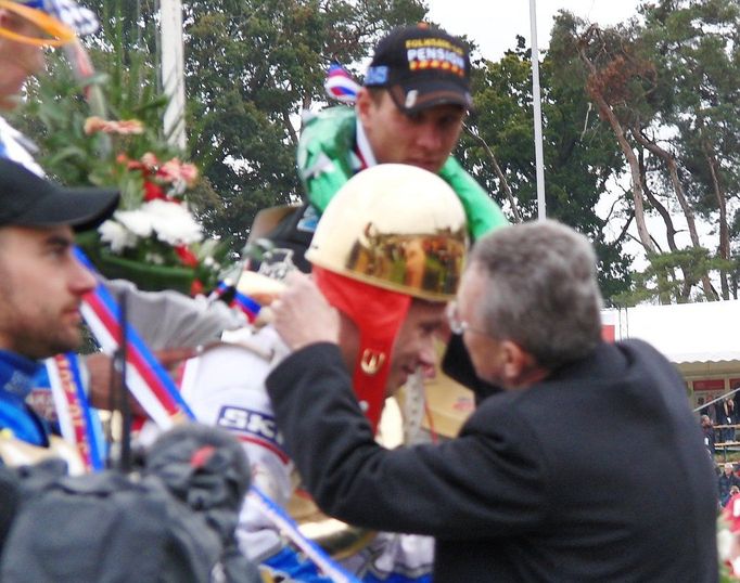 Vítěz si prošel všemi tradičními ceremoniemi, které jsou s 62 roků starým závodem spjaty. Zde mu pardubický zlatník Pavel Lejhanec dlouze připíná svůj výtvor - zlatou přilbu, která jako tradičně nechtěla na šampionově hlavě držet.