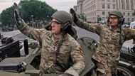 Nadporučík Zachary Buher a rotný Cesar Lua na tanku M1A2 SEP V3 zdraví diváky přehlídky.