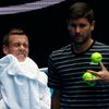 Czech Reprublic's Tomas Berdych (L) wipes his face as his coach Danny Vallverdu gathers tennis balls during a practice session at Melbourne Park, Australia