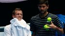 Czech Reprublic's Tomas Berdych (L) wipes his face as his coach Danny Vallverdu gathers tennis balls during a practice session at Melbourne Park, Australia