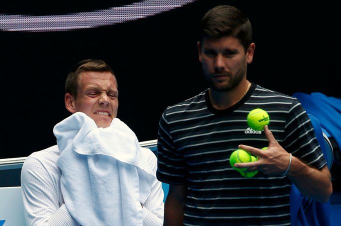 Czech Reprublic's Tomas Berdych (L) wipes his face as his coach Danny Vallverdu gathers tennis balls during a practice session at Melbourne Park, Australia