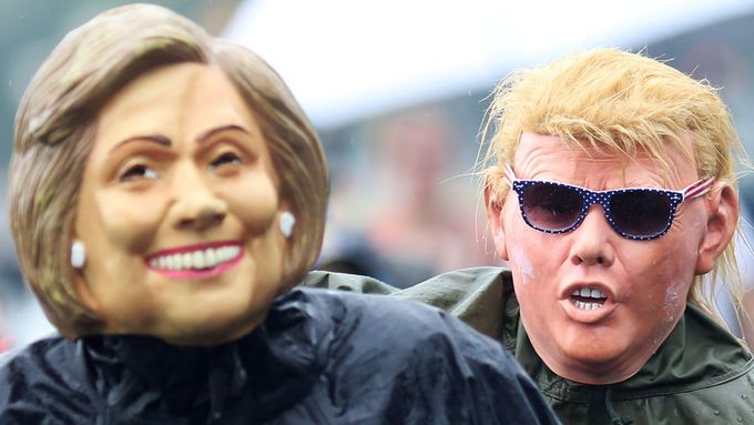 Účastníci demonstrace během demokratického sjezdu v maskách Hillary Clintonové a Donalda Trumpa