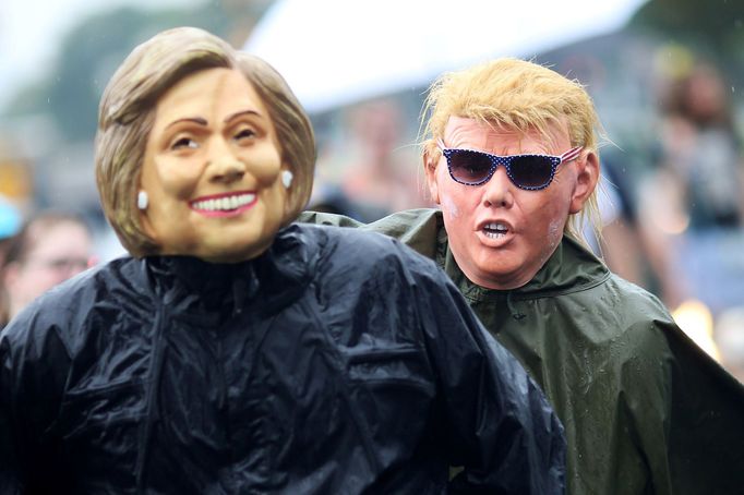 Účastníci demonstrace během demokratického sjezdu v maskách Hillary Clintonové a Donalda Trumpa