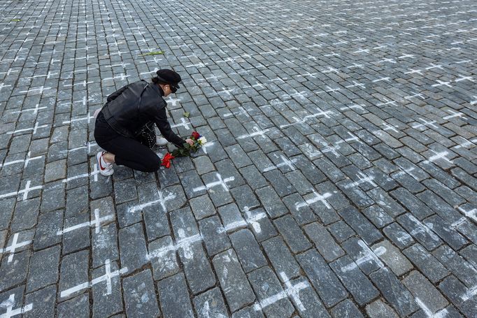 Lidé na Staroměstském náměstí v Praze spontánně uctívají oběti pandemie u křížů, které zde křídou nakreslila iniciativa Milion chvilek pro demokracii. 24 - 25. 3. 2021