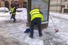 Muži uklízejí sníh před základní školou ve Vodičkově ulici.