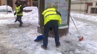 Muži uklízejí sníh před základní školou ve Vodičkově ulici.