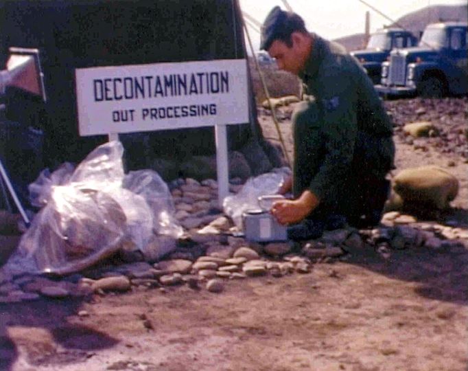 Americký voják s troskami nalezenými po zřícení dvou letounů USA v roce 1966.