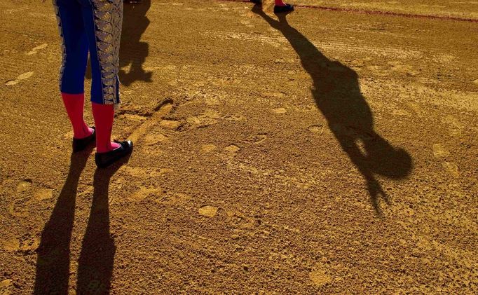 Colombian matador Luis Bolivar salutes the crowd as his assistant Gustavo Garcia stands after making a cross with his foot on the arena before the start of a bullfight in The Maestranza bullring in Seville