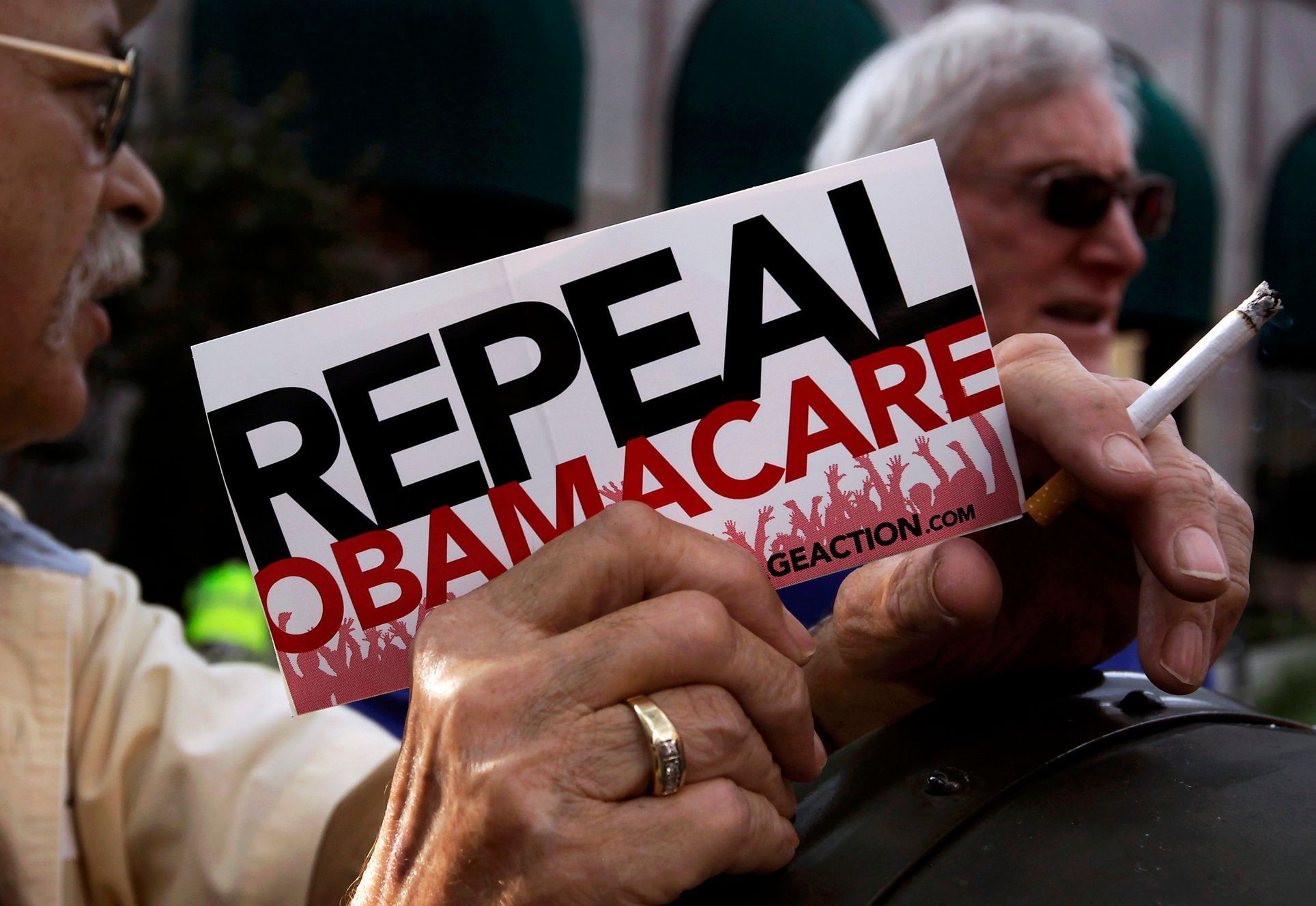 Demonstrant drží ceduli "Zrušte Obamacare".