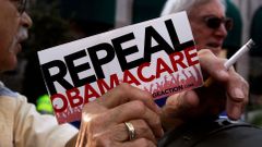 Demonstrant drží ceduli "Zrušte Obamacare".