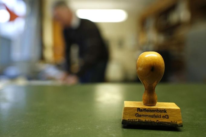 A Raiffeisen Gammesfeld eG bank stamp is pictured at the bank in Gammesfeld, Baden-Wuerttemberg January 29, 2013. The Raiffeisen Gammesfeld eG cooperative bank is one of the country's smallest banks and is the only one to be run by just one member of staff. All banking duties are done by CEO Peter Breiter who records the daily business by hand, partly on paper. The bank is not connected to a database system, there are no automatic teller machines (ATMs) and its customer base consists only of residents of the town of Gammesfeld which has a population of around 510. Picture taken January 29, 2013. REUTERS/Lisi Niesner (GERMANY - Tags: BUSINESS SOCIETY) ATTENTION EDITORS: PICTURE 16 OF 26 FOR PACKAGE 'GERMANY'S ONE MAN BANK'. TO FIND ALL IMAGES SEARCH 'Raiffeisen' Published: Úno. 13, 2013, 10:02 dop.