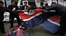 Activists from an anti-North Korea civic group try to tear a North Korea flag during a rally against North Korea's nuclear test near the U.S. embassy in central Seoul February 12, 2013. North Korea conducted its third nuclear test on Tuesday in defiance of U.N. resolutions, angering the United States and Japan and prompting its only major ally, China, to call for calm. REUTERS/Kim Hong-Ji (SOUTH KOREA - Tags: CIVIL UNREST POLITICS TPX IMAGES OF THE DAY) Published: Úno. 12, 2013, 9:01 dop.