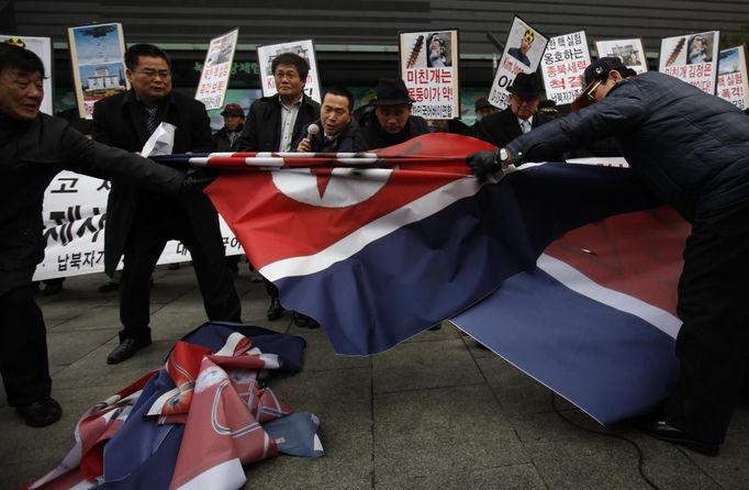 Activists from an anti-North Korea civic group try to tear a North Korea flag during a rally against North Korea's nuclear test near the U.S. embassy in central Seoul February 12, 2013. North Korea conducted its third nuclear test on Tuesday in defiance of U.N. resolutions, angering the United States and Japan and prompting its only major ally, China, to call for calm. REUTERS/Kim Hong-Ji (SOUTH KOREA - Tags: CIVIL UNREST POLITICS TPX IMAGES OF THE DAY) Published: Úno. 12, 2013, 9:01 dop.