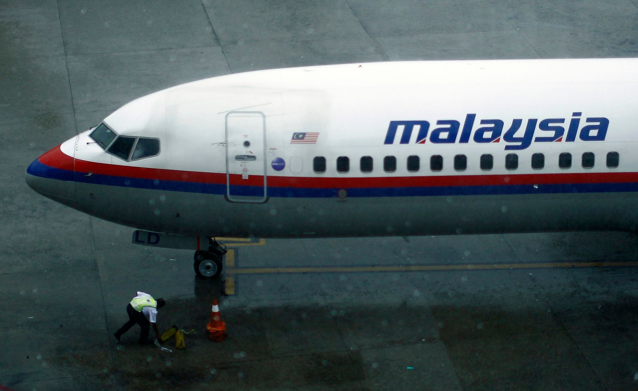 A ground staff works near a Malaysia Airlines aircraft at the Kuala Lumpur International Airport in Sepang