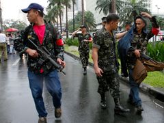Vzbouření vojáci pochodují od soudu směrem k Peninsula hotelu v Manile.