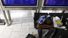 A passenger sits under a monitor with a flight schedule as he waits for a transfer at the Fraport airport in Frankfurt, September 4, 2012. German air carrier Lufthansa passengers face widespread flight disruption after cabin crew representatives said they continue a series of strikes over pay and cost-cutting measures at Germany's largest airline. The UFO union, which represents around two-thirds of Lufthansa's 19,000 cabin crew, late on Thursday called on its members to strike in Frankfurt and Berlin. REUTERS/Kai Pfaffenbach (GERMANY - Tags: BUSINESS EMPLOYMENT CIVIL UNREST TRANSPORT) Published: Zář. 4, 2012, 12:36 odp.